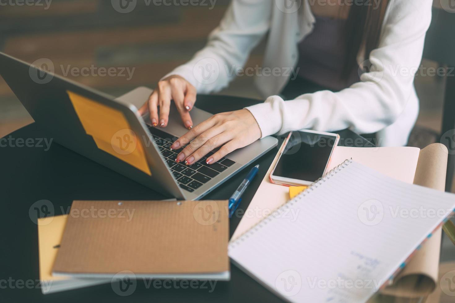 unga vuxna kvinnor hand studerar och arbetar online vid kafébord med laptop. foto