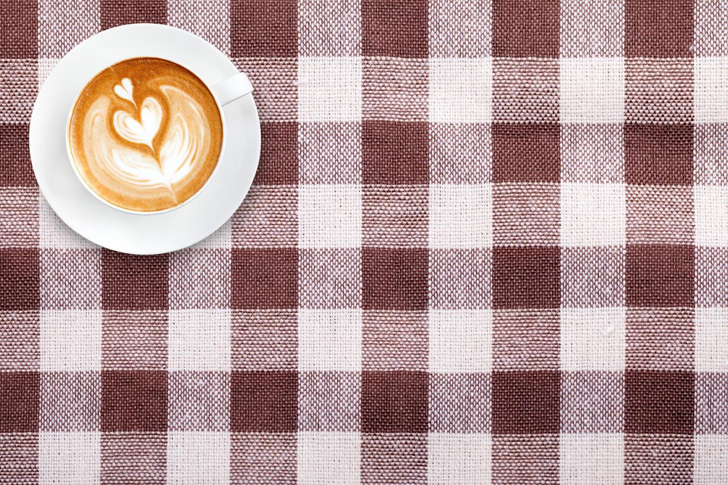 ovanifrån latte art kaffe på tyg textil textur bakgrund foto