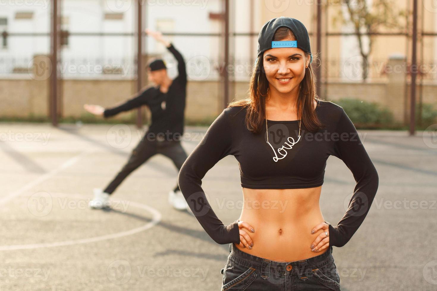 porträtt av en vacker dansare flicka på en bakgrund av hip hop dansare. foto