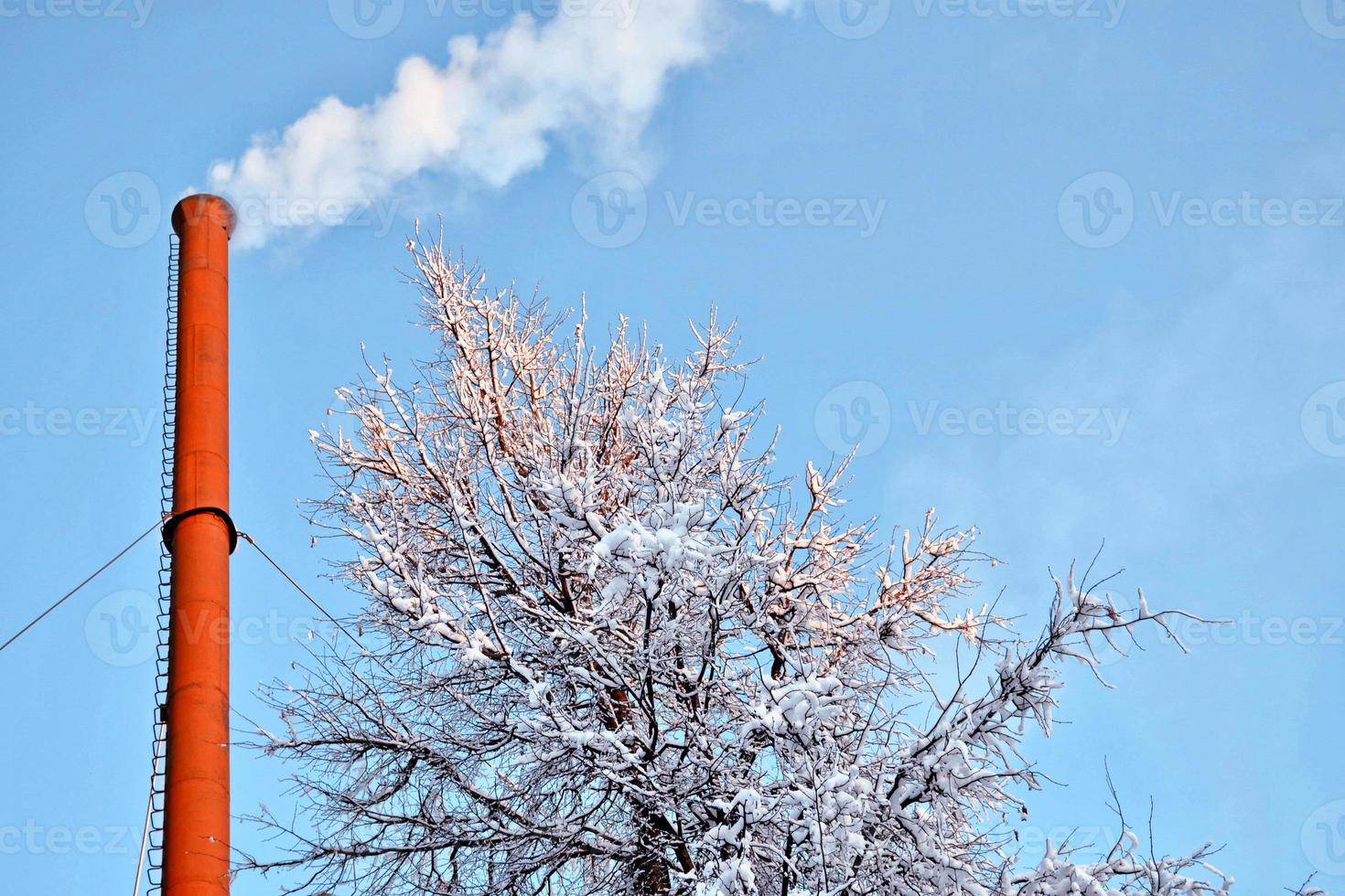 rör i ett värmekraftverk rök mot den blå himlen. foto
