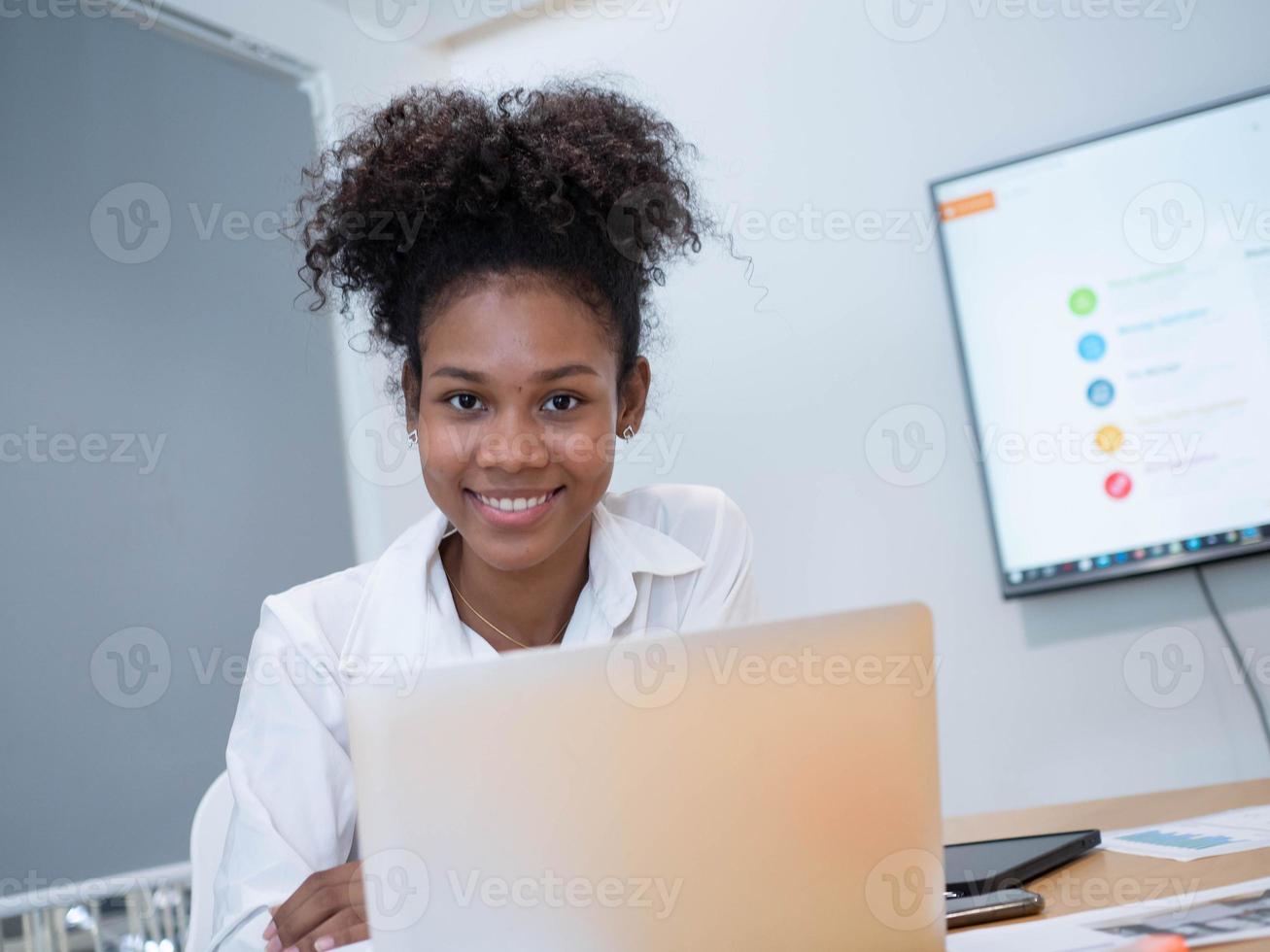 affärskvinna chef verkställande afrikansk person mångfald arbete jobb karriär bärbar dator anteckningsbok elektronisk teknologi digital blick på kameran lyckligt leende inomhus kontor företag foto