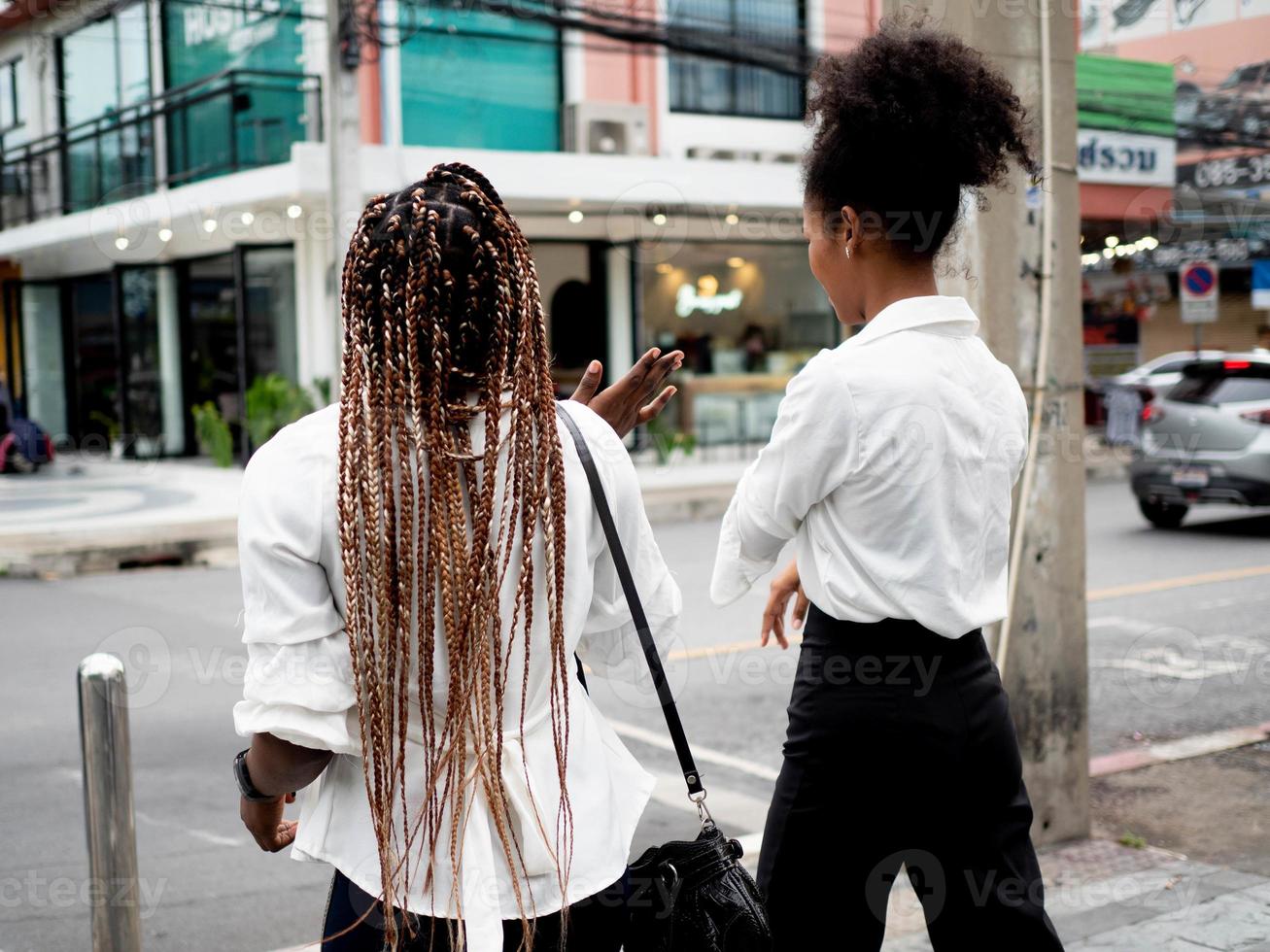 baksidan kvinnlig och manlig mångfald afrikansk afro hår promenader prata vänskap universitetsutbildning multiracial grupp kollega partner gata livsstil frihet slappna av njuta roligt utomhus resor foto