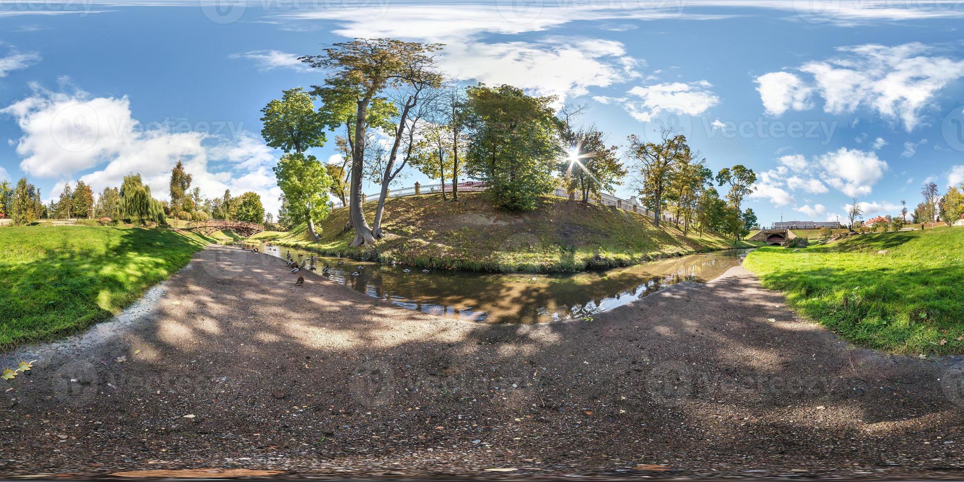 fullt sömlöst sfäriskt panorama 360 gånger 180 graders vinkelvy på stranden av en liten flod med ankor i stadsparken på sommardagen i ekvirektangulär projektion, ar vr virtual reality-innehåll foto
