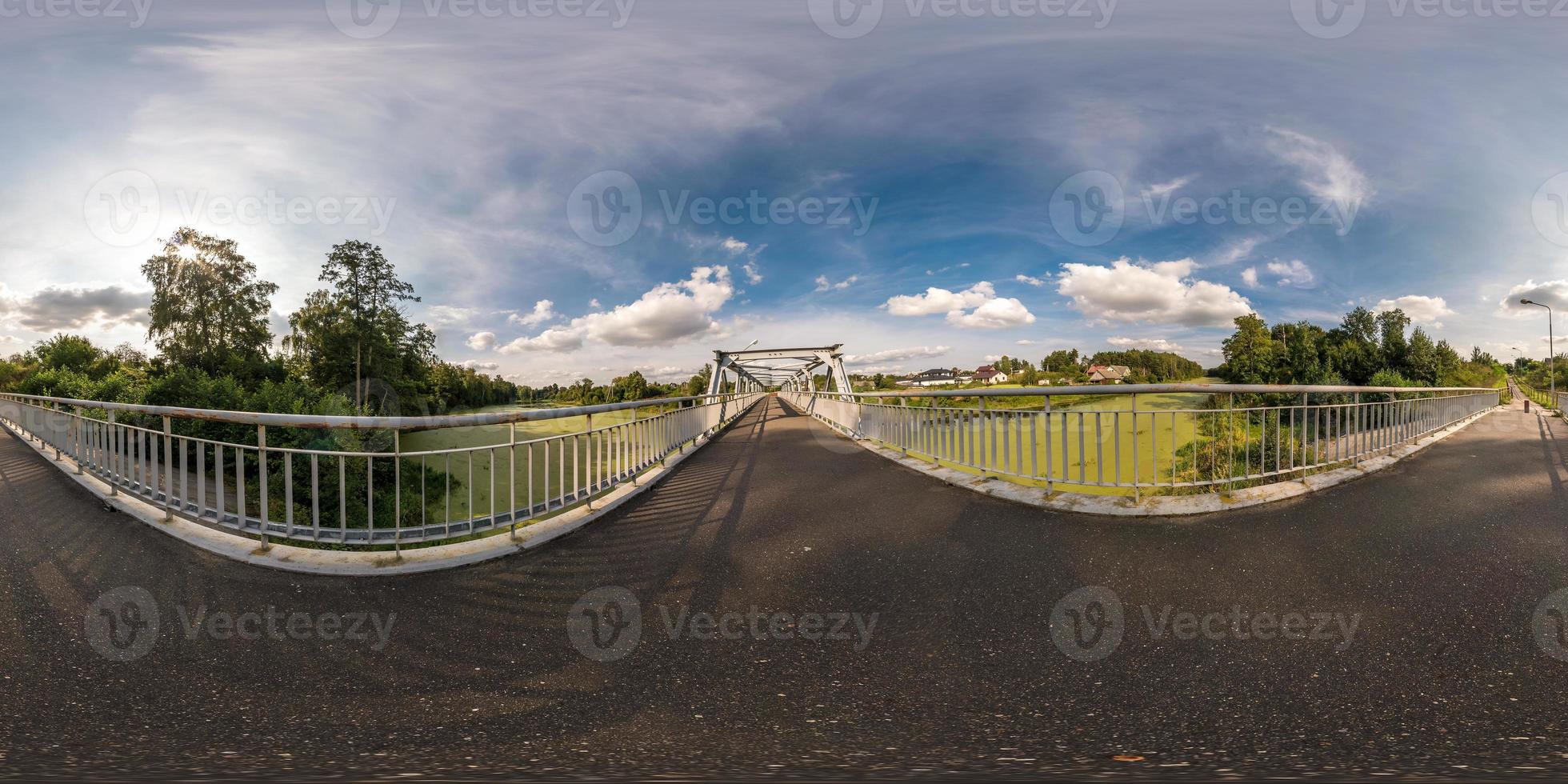 fullständigt sömlöst sfäriskt panorama 360 x 180 vinkelvy nära järnstålramkonstruktion av gångbro över floden i ekvirektangulär projektion, redo för virtuell verklighetsinnehåll foto