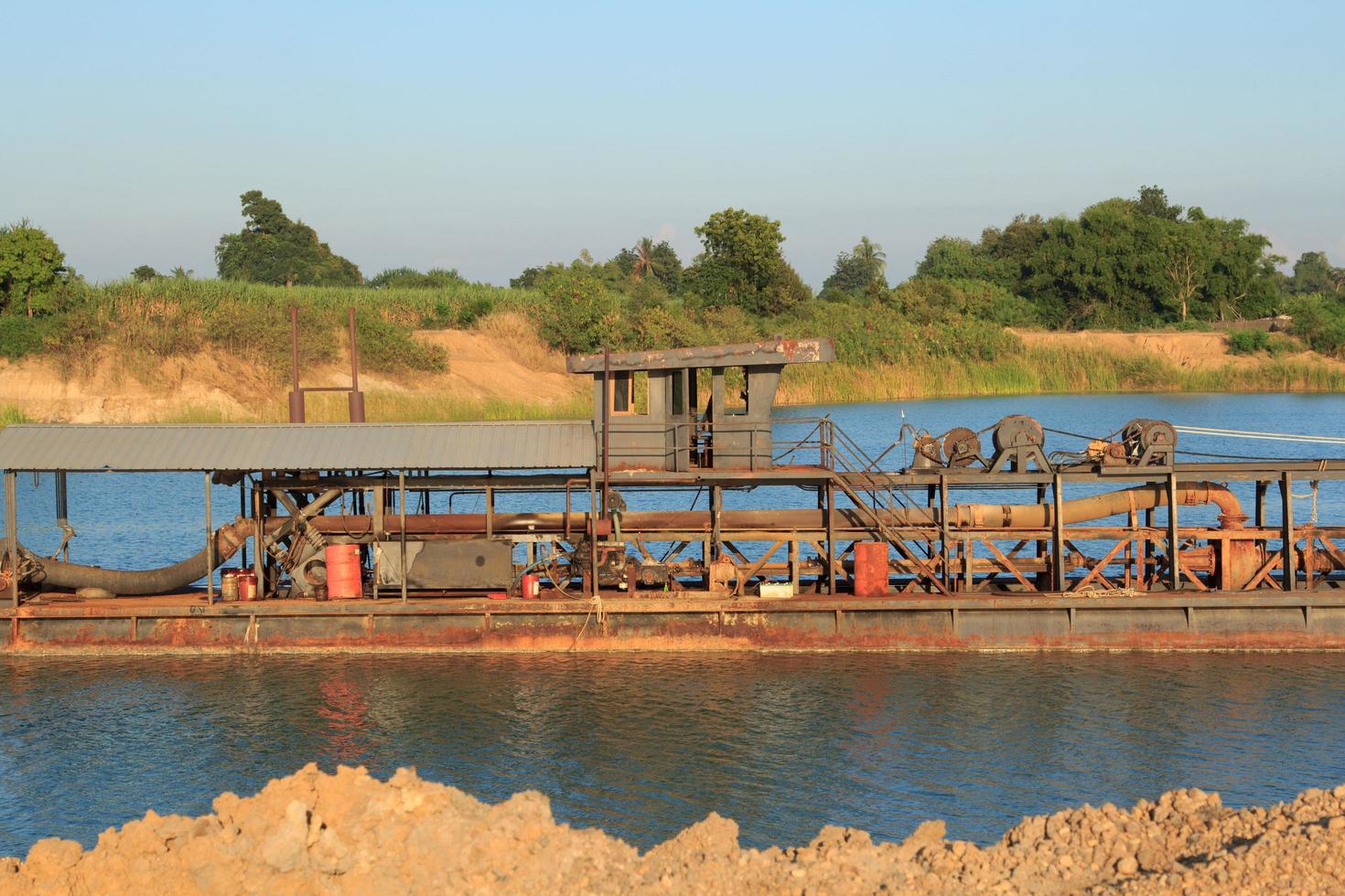 sandsugningsfartyg transporterar sand från stålrör i djupa floder för konstruktion av industrier som hus, byggnader, vägar och många andra där sand används som en blandning. foto