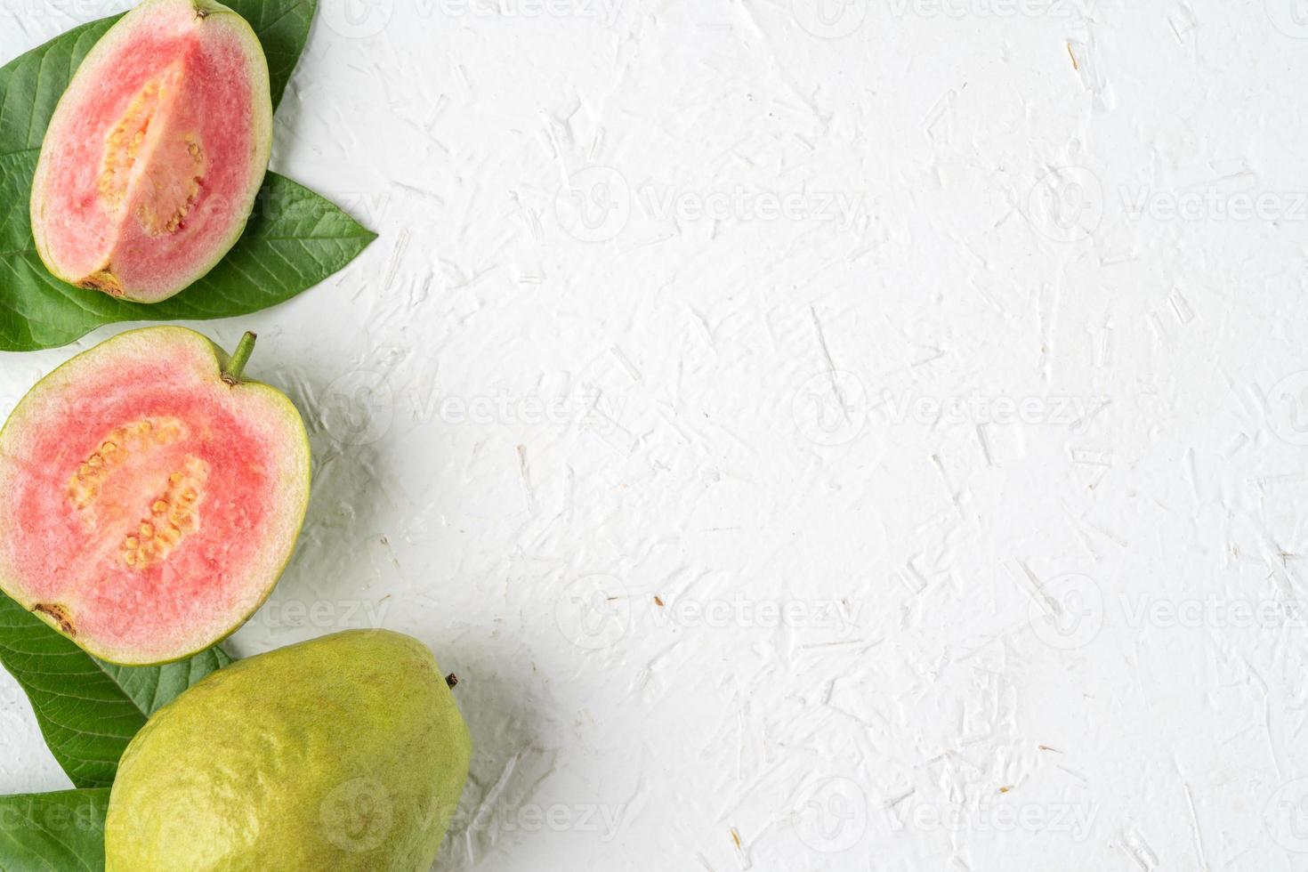 ovanifrån av vacker röd guava med färska gröna blad. foto