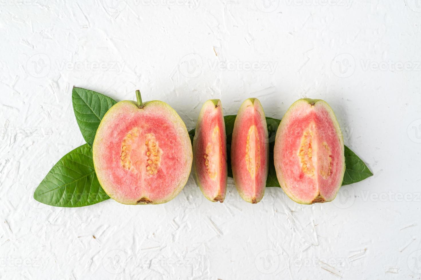 ovanifrån av vacker röd guava med färska gröna blad. foto