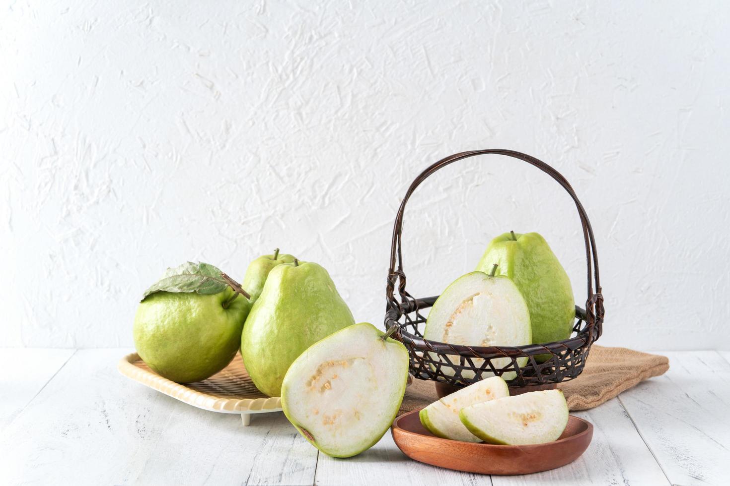 läcker guava frukt set på vit träbord bakgrund med kopia utrymme. foto