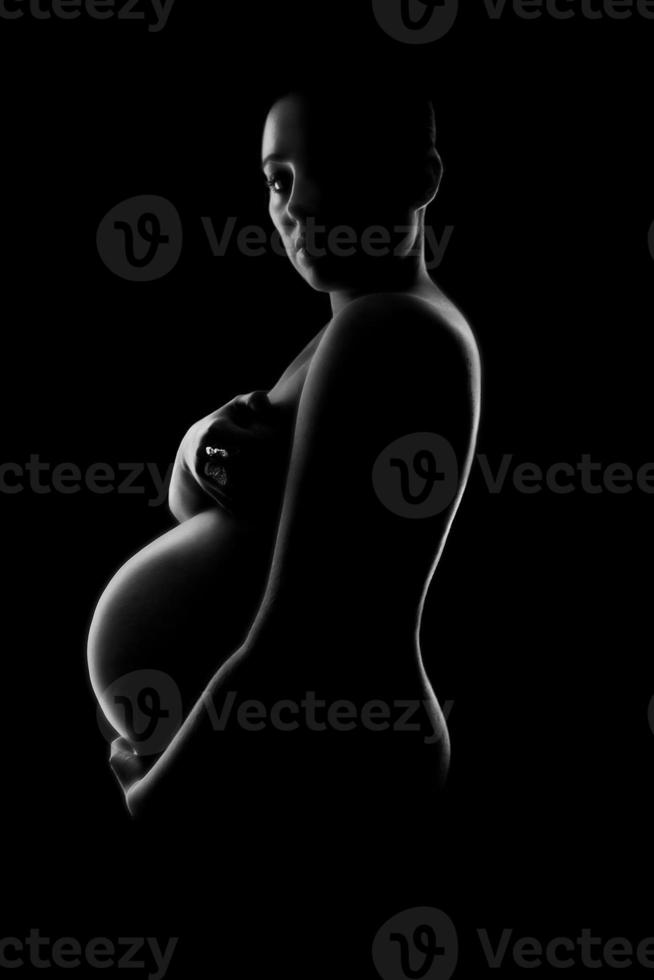 ung, gravid kvinna kramar hennes bula foto