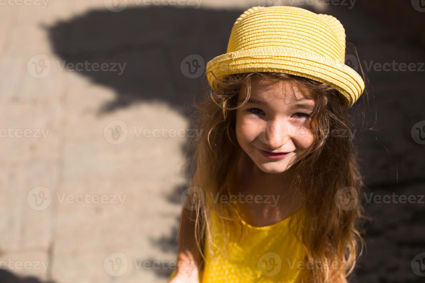 närbild av ett sommarporträtt av en flicka i en gul hatt och solklänning. solig sommartid, frihet, foto