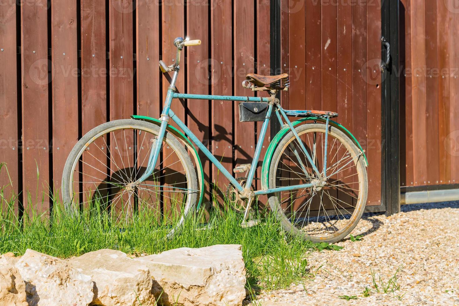 gammal cykel parkerad vid ett trästaket, landsbygdslandskap foto