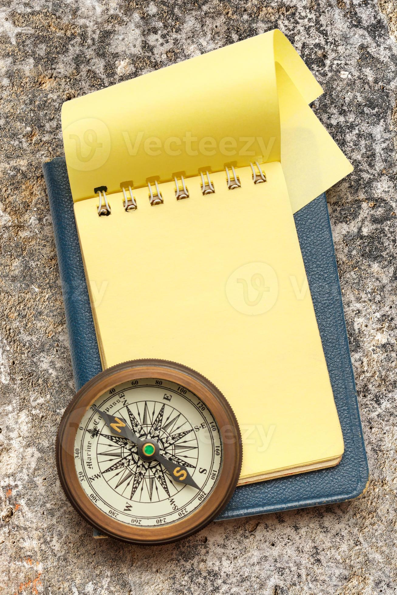 vintage kompass och tom gul anteckningsblock foto