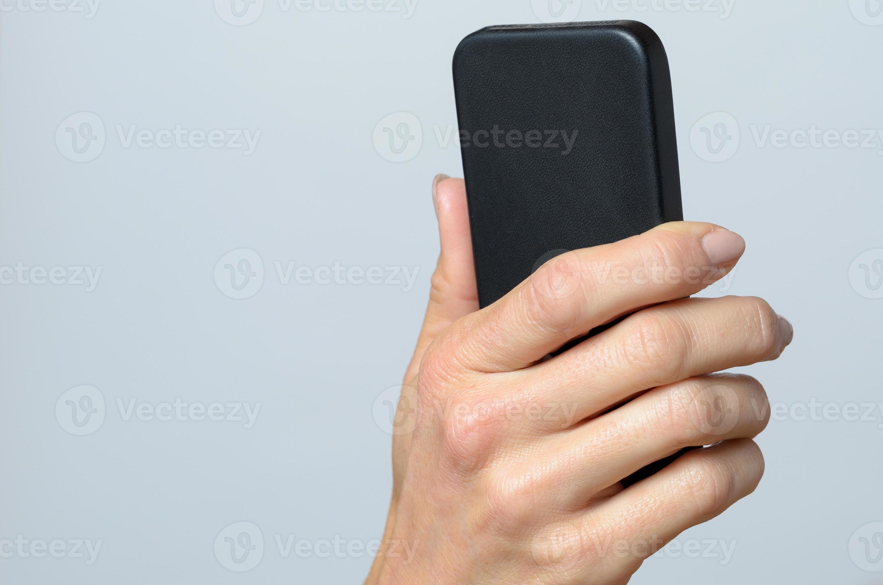 hand som håller en svart cellulär foto