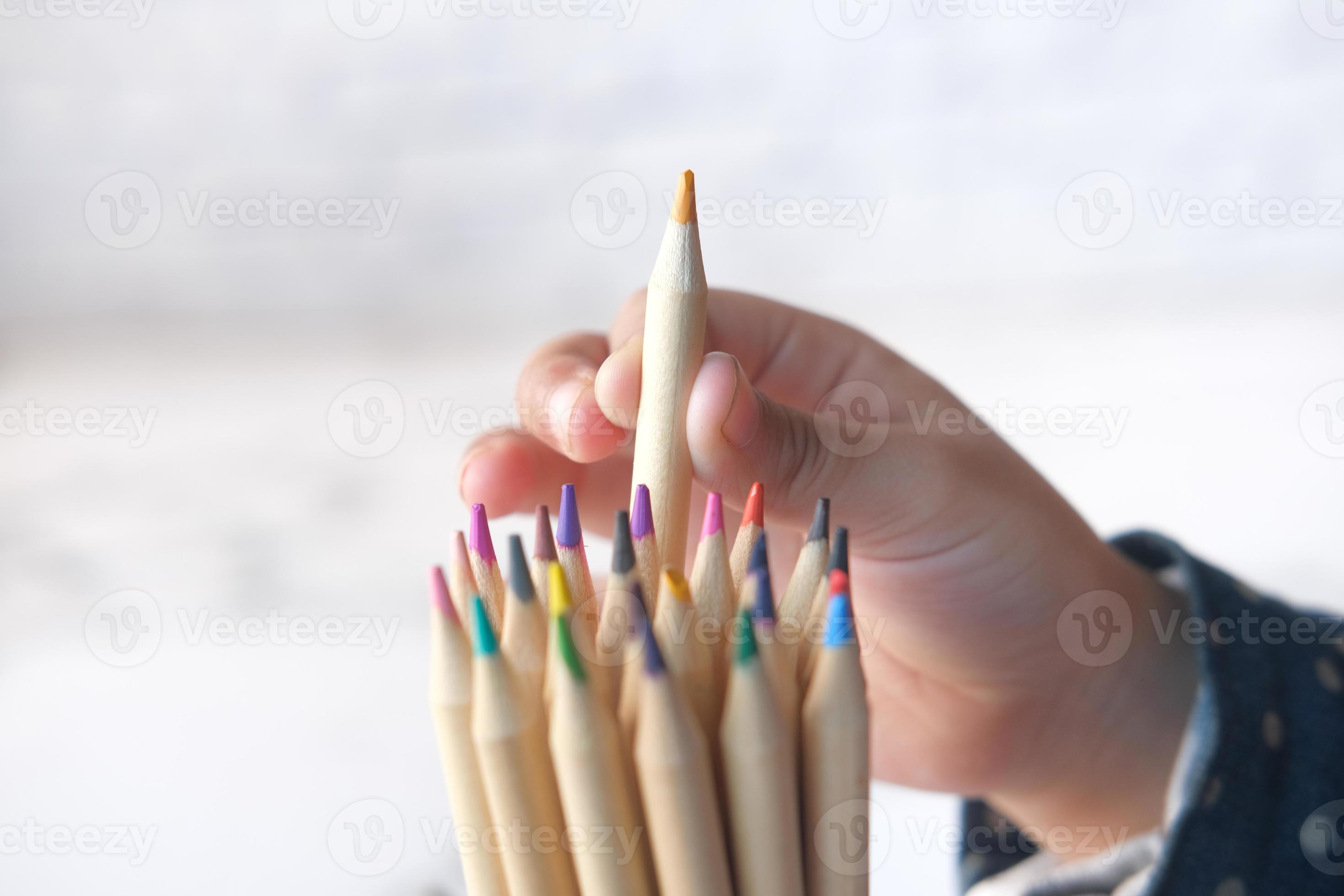 barnflicka som väljer en färgpenna från en låda foto