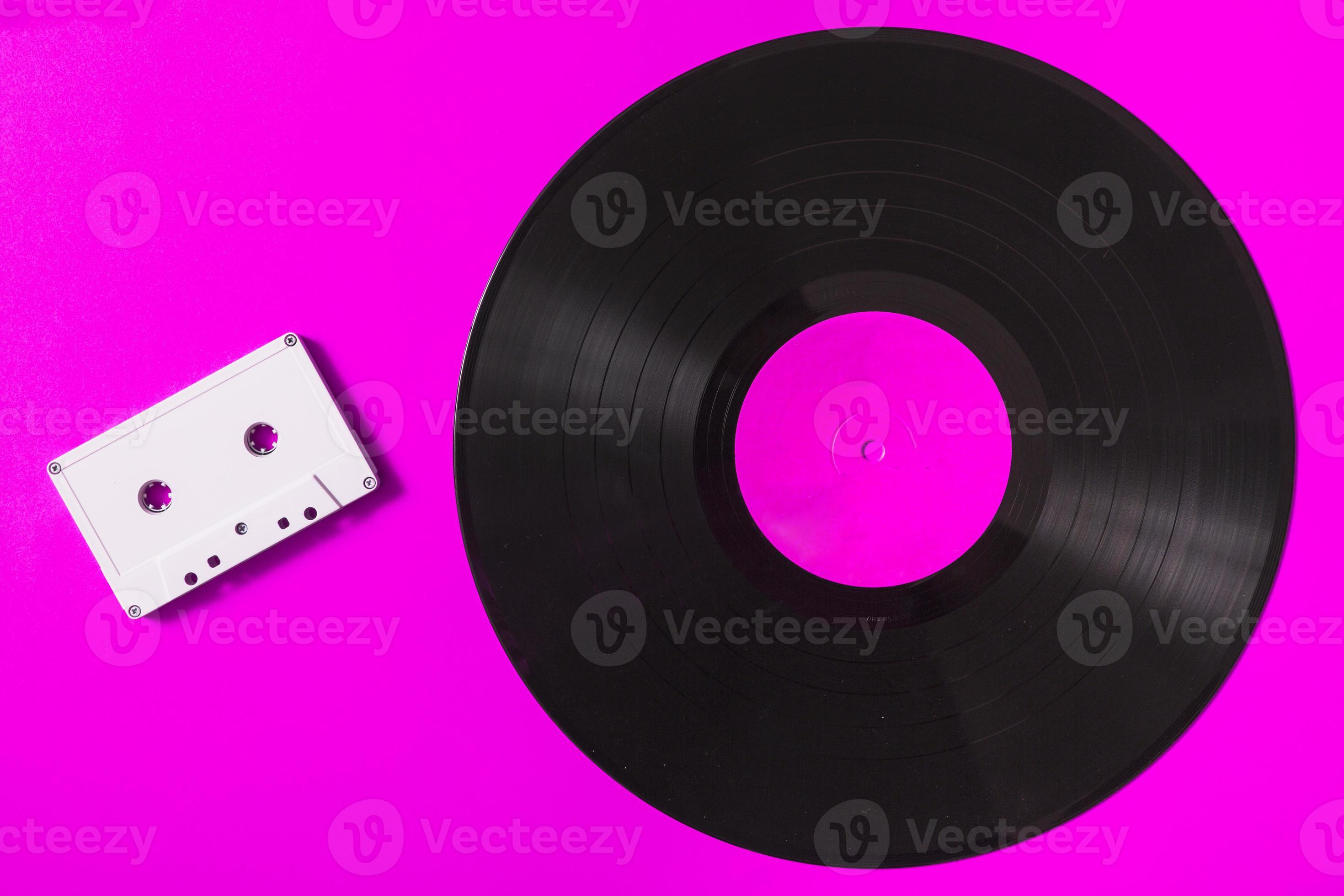 vitt ljudkassettband och vinylskiva på rosa bakgrund foto