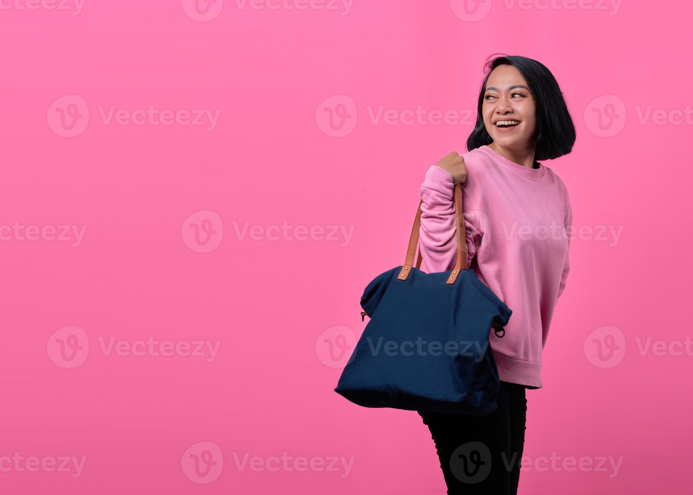 porträtt av den glada unga asiatiska kvinnan som håller påsen medan du handlar foto