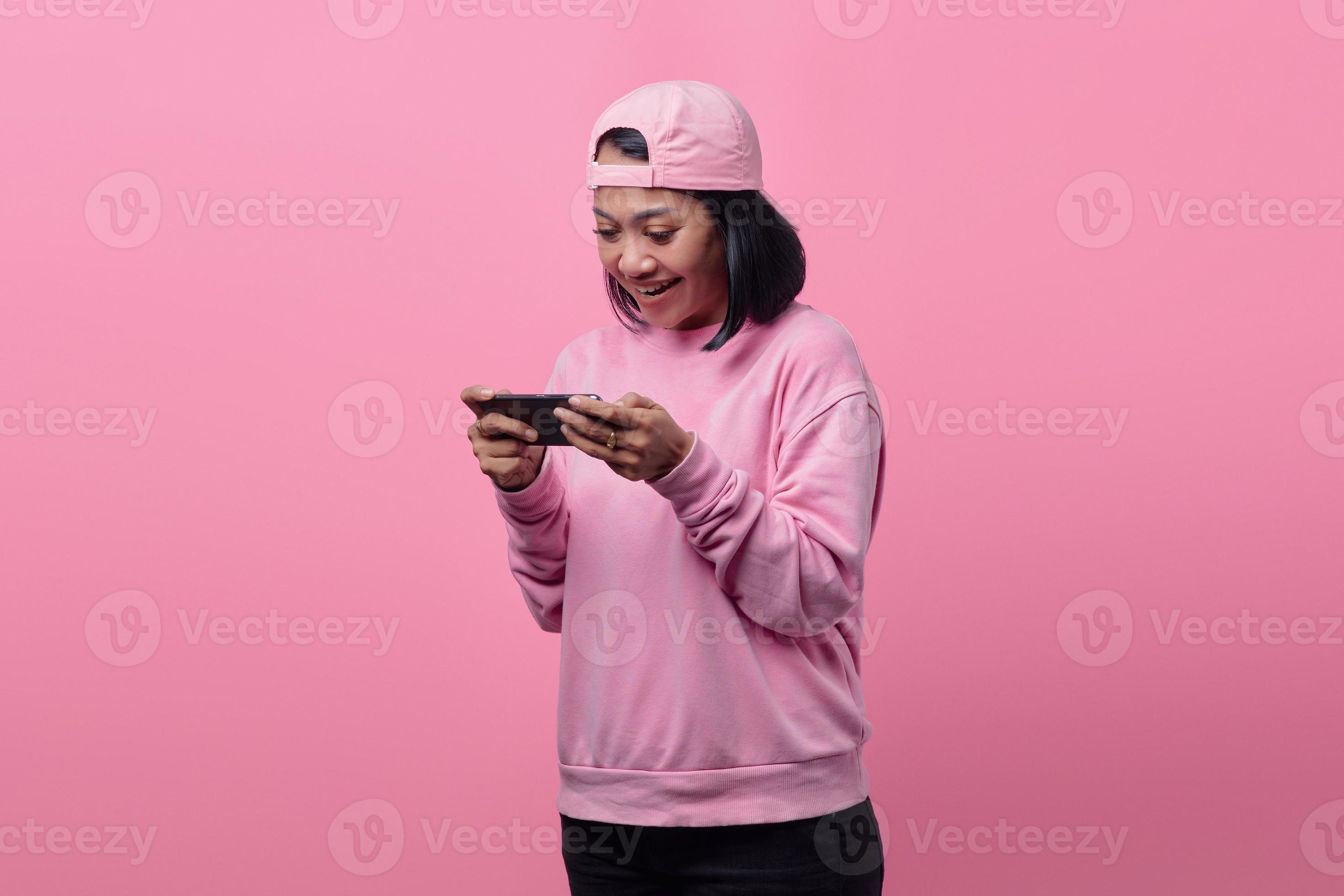 vacker asiatisk kvinna som spelar videospel på smartphone foto