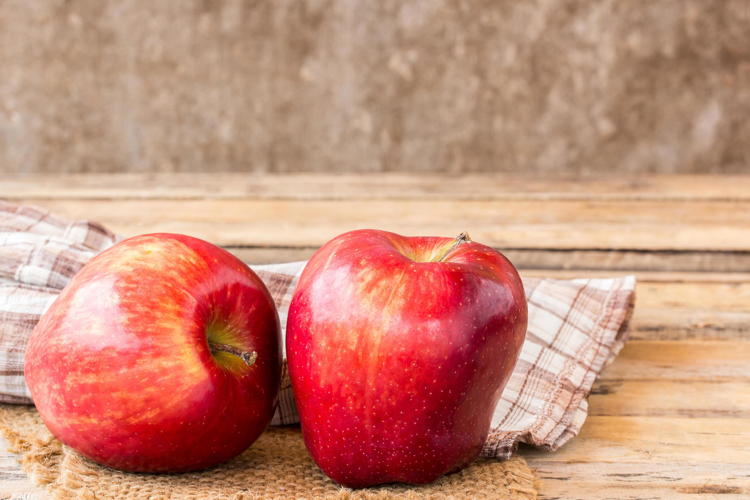 färskt rött äpple på träbord foto