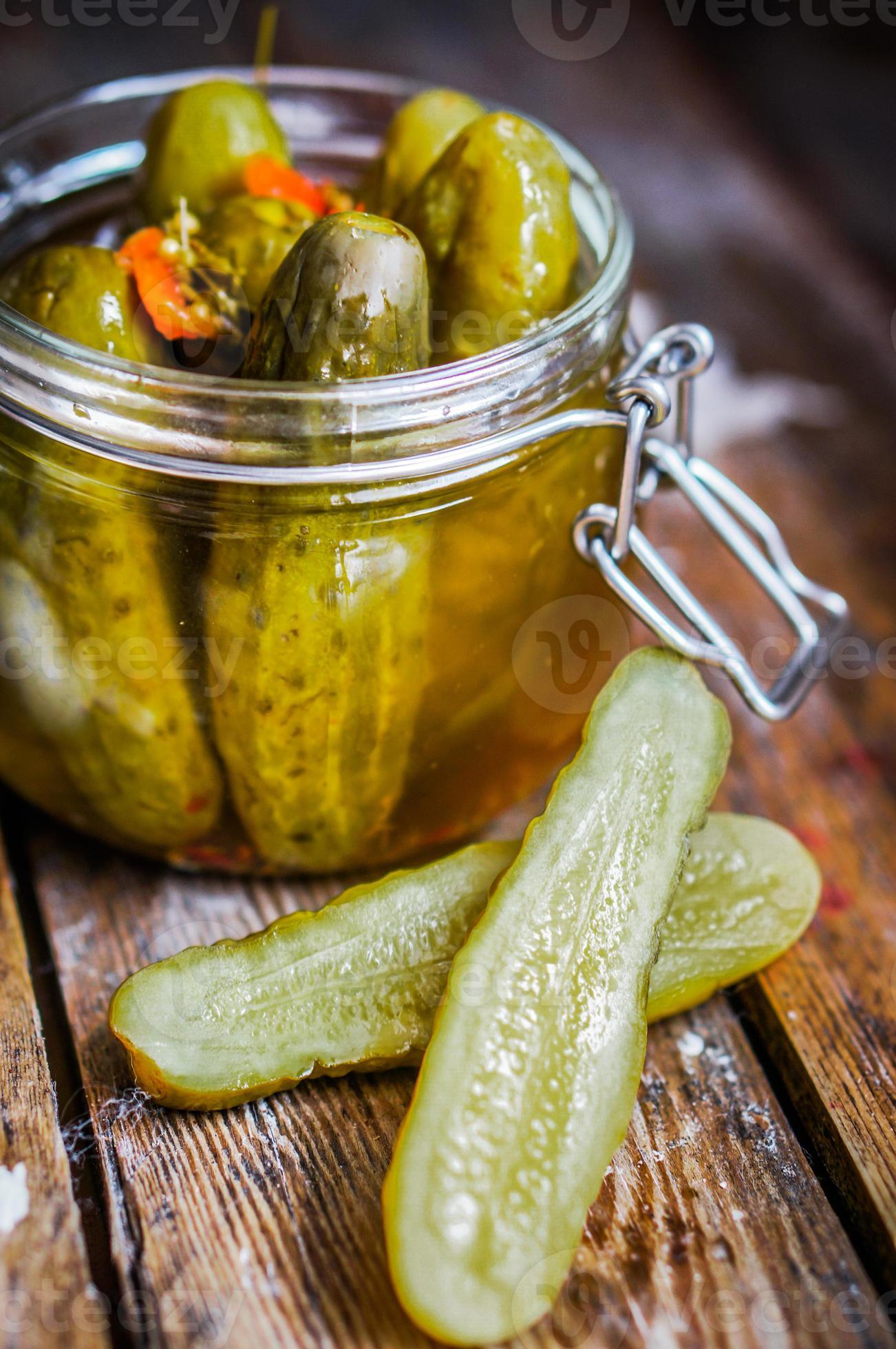 pickles med vitlök i glasburk på rustik träbakgrund foto