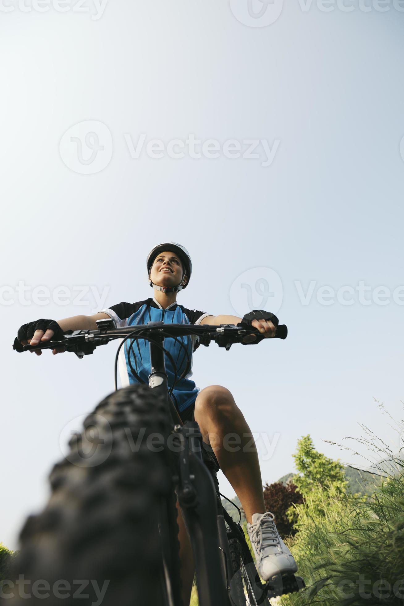 ung kvinna utbildning på mountainbike och cykla i park foto