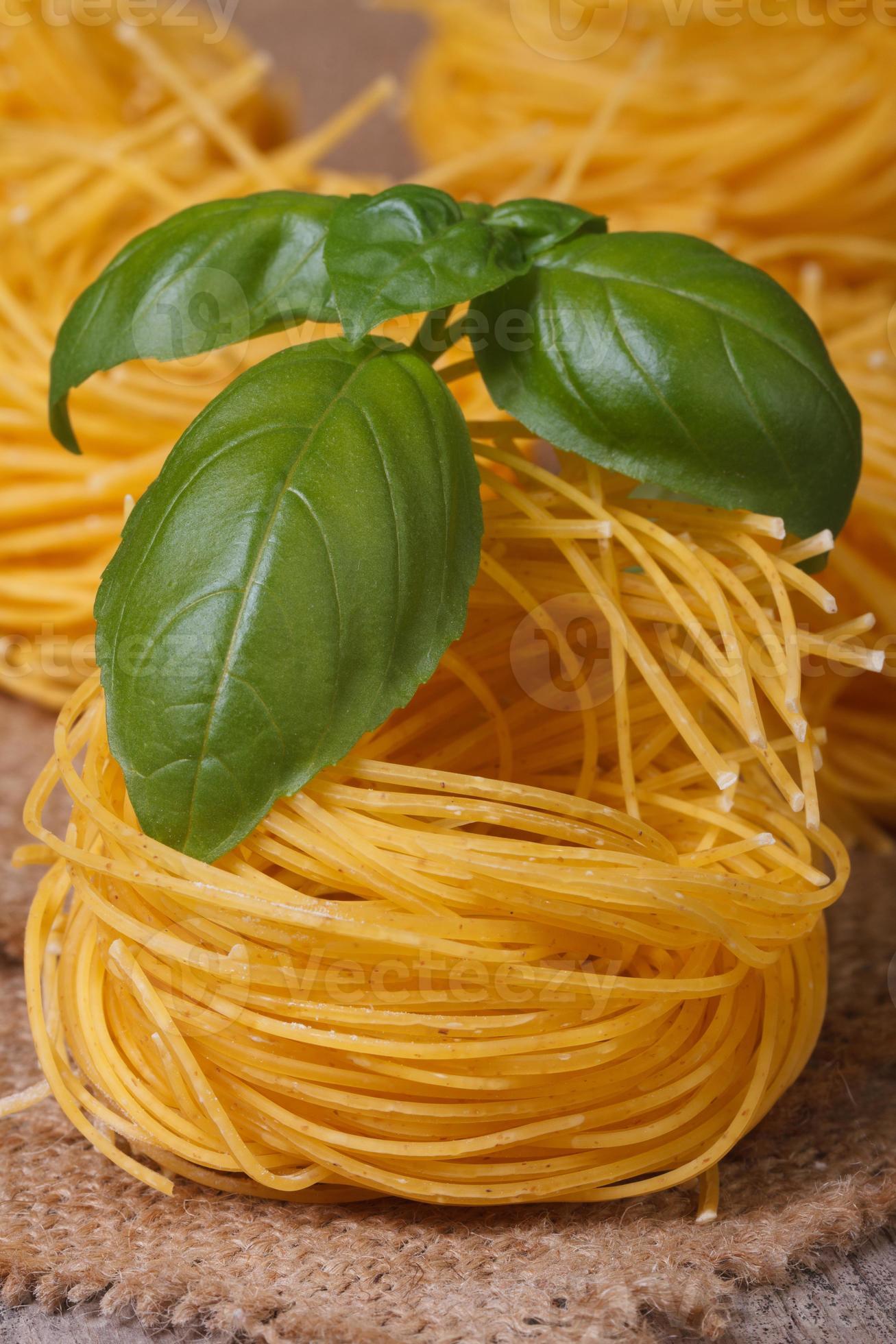 torr pasta bo närbild med grön basilika på bordet. foto