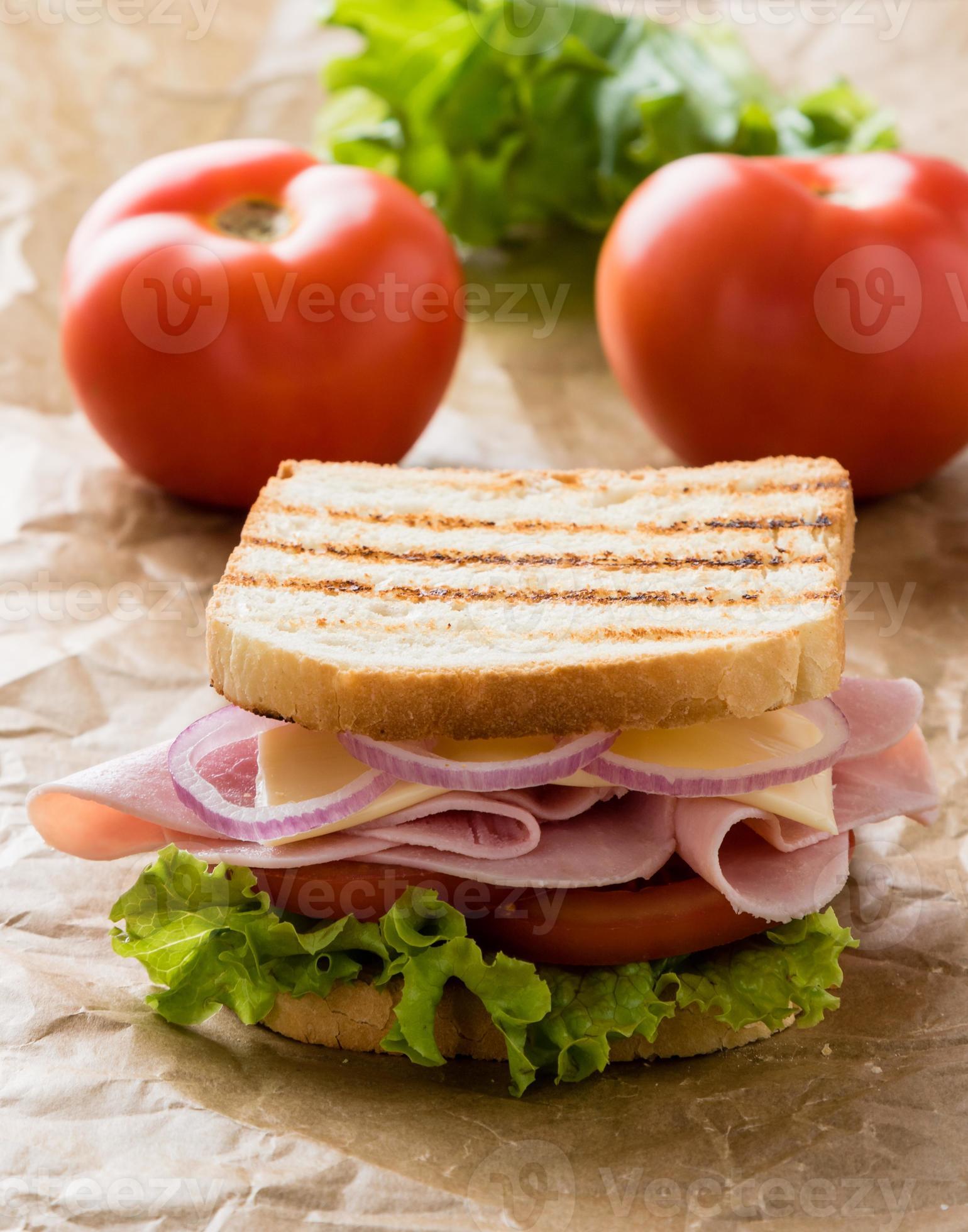 toast skinkasmörgås på brunt papper foto