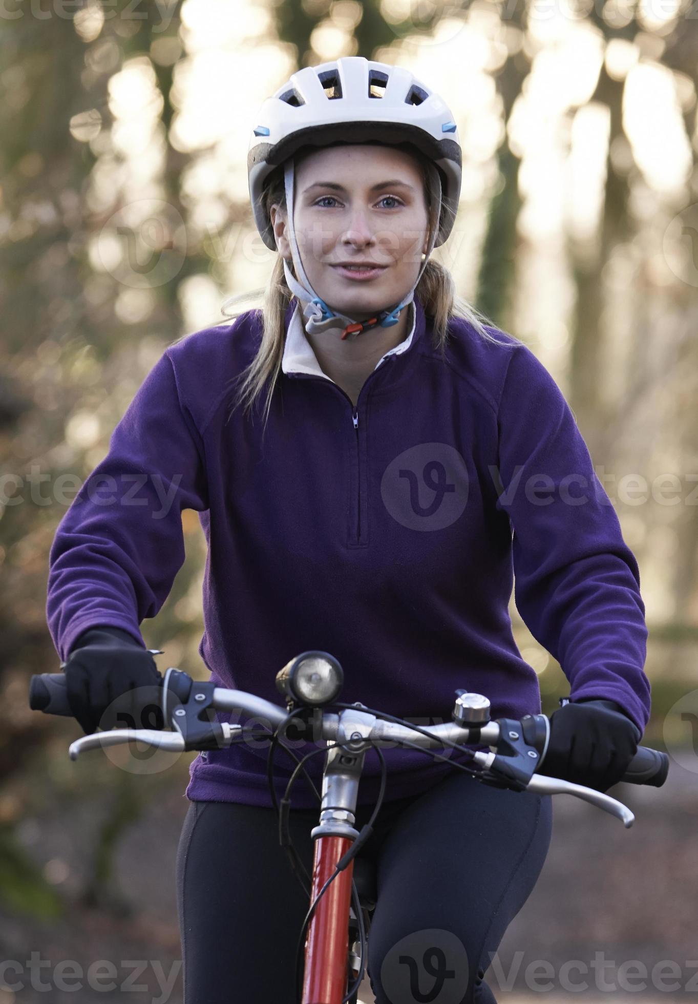 kvinna ridning mountainbike genom skogsmark foto