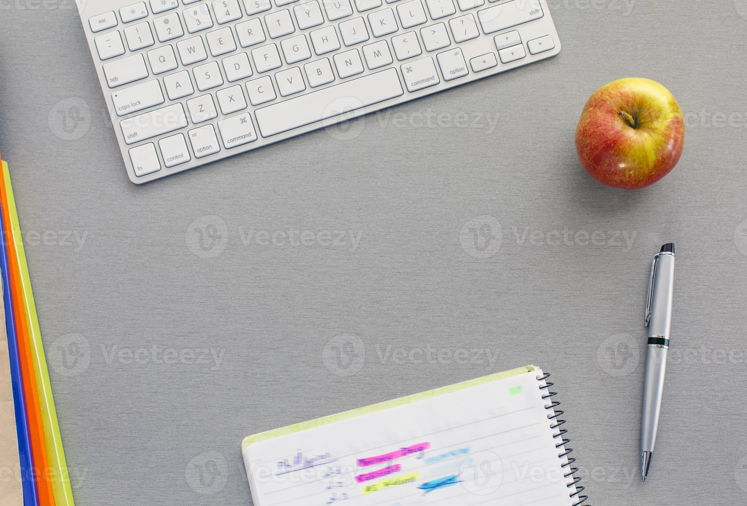 kontorsarbetsplats på grått skrivbord med rött äpple foto