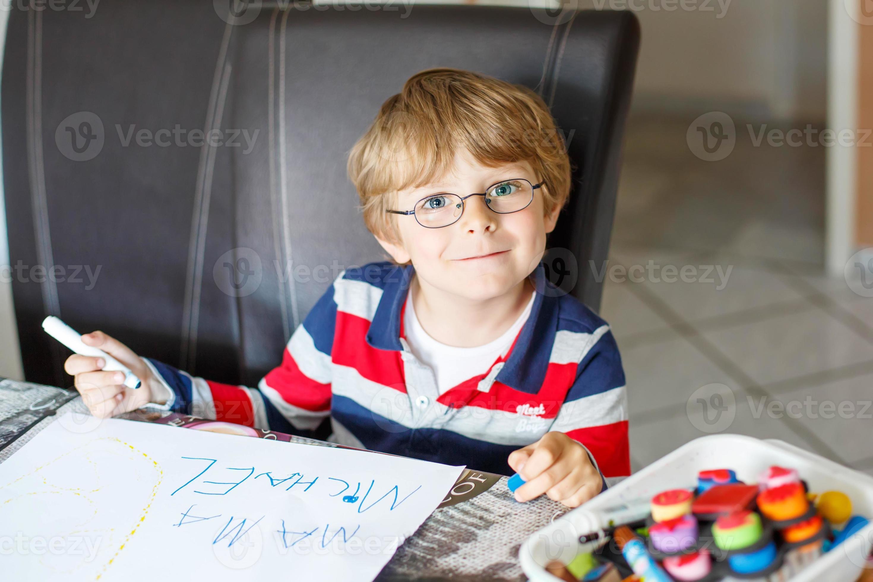 barnpojke i glas som gör läxor hemma foto