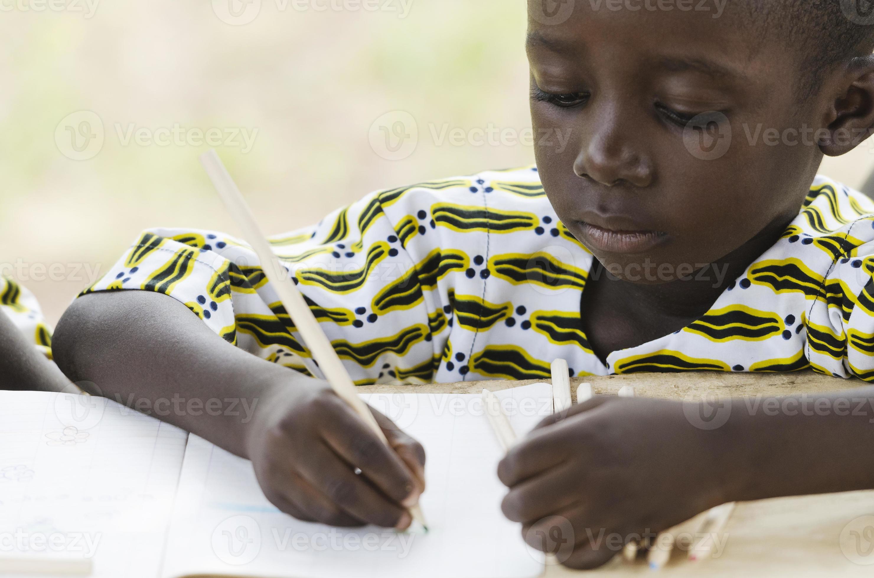 svart pojke som skriver och skriver i skolan foto