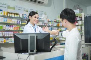 kvinnlig farmaceut som ger kundrådgivning om droganvändning i ett modernt apotek. foto