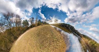 liten planetomvandling med krökning av rymden. sfärisk antenn 360 panoramautsikt på stranden av sjön i solig sommar med fantastiska moln. foto