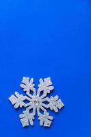 jul bakgrund av silver glitter snöflinga dekoration på blå färg bakgrund. foto