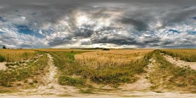 full sömlös sfärisk hdri panorama 360 graders vinkelvy på grusväg bland åkrar på sommarkvällen med häftiga moln i ekvirektangulär projektion, redo för vr ar virtual reality-innehåll foto