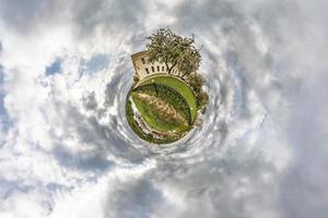 liten planetomvandling av sfäriskt panorama 360 grader. sfärisk abstrakt flygfoto i fältet i trevlig kväll med fantastiska vackra moln. utrymmets krökning. foto