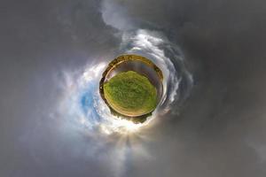 liten planetomvandling av sfäriskt panorama 360 grader. sfärisk abstrakt flygfoto i fältet i trevlig kväll med fantastiska vackra moln. utrymmets krökning. foto