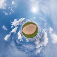 liten planetomvandling av sfäriskt panorama 360 grader. sfärisk abstrakt flygfoto i fältet i trevlig kväll med fantastiska vackra moln. utrymmets krökning. foto