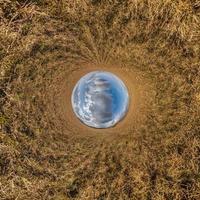 blå himmel boll i mitten av virvlande fält. inversion av liten planettransformation av sfäriskt panorama 360 grader. utrymmets krökning. foto
