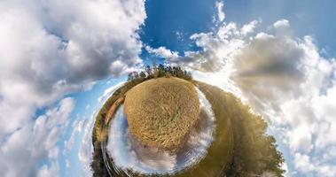 liten planetomvandling med krökning av rymden. sfärisk antenn 360 panoramautsikt på stranden av sjön i solig sommar med fantastiska moln. foto