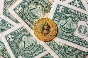 virtuella pengar gyllene bitcoin på en dollarsedel bakgrund. begreppet ny världsordning av kryptovaluta. byta bitcoin kontanter mot en dollar. foto
