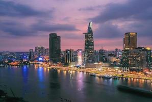 utsikt över bitexco finansiella tornbyggnad, byggnader, vägar, thu thiem bridge och saigon river i ho chi minh city i solnedgången. panoramabild av hög kvalitet. foto