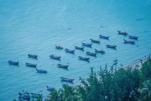 Flygfoto många lokala kulturen vietnam. ovanifrån av lokala fiskarbåtar i det djupblå havet, tropiskt havslandskap. resmål asien koncept och bakgrund. foto