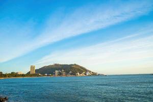 vung tau stadens flygfoto med vacker solnedgång och så många båtar. panoramautsikt över kustnära vung tau från ovan, med vågor, kustlinje, gator, kokospalmer och tao phung-berget i vietnam. foto