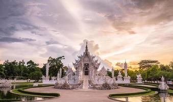 'det vita templet' i chiang rai, även känt som 'wat rong khun' på thai, den bisarra skapelse av den thailändska nationalkonstnären chalermchai kositpipat vid solnedgången. foto