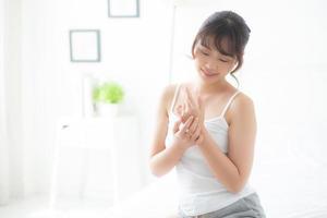 ung asiatisk kvinna som applicerar kräm och behandling för hudvård touch till hands, Asien flicka med lotion spa och återfuktande för hälsa och välbefinnande kroppsdel, livsstil och skönhet kosmetiska koncept. foto