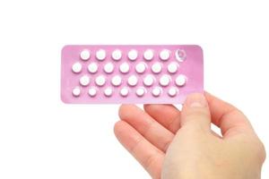 tabletter piller med kvinna hand, isolerad på vit bakgrund foto
