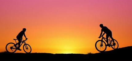 siluett av en mountainbikecyklist som njuter av nedförsbacke under solnedgången. mountainbike koncept. mountainbike race - siluett cyklist på bakgrunden. foto