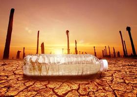 begreppet vattenbrist torka på grund av global uppvärmning. vattenflaskor placerade i torka och trasiga jordområden foto
