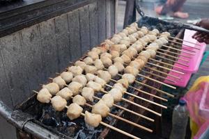 selektivt fokus på grillade köttbullar med spett med bambu och som säljs på kulinariska festivaler foto