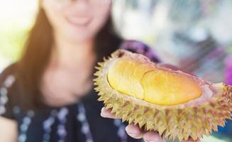 närbild av redo att äta durian frukt i lady hand foto